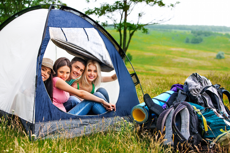 Group people with backpack in tent hide from rain summer outdoor.